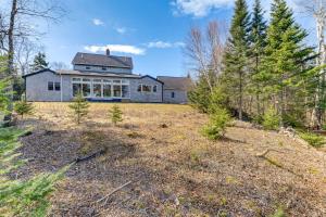 a large house in the middle of a field at Chic Addison Home with Fire Pit on 8 Private Acres! in Milbridge