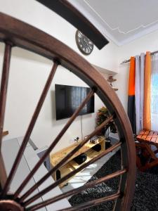 a living room with a tv and a wooden wheel at Kindiha homes. in Seeta