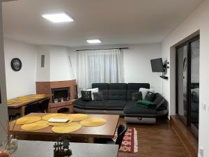 - un salon avec un canapé et une table dans l'établissement Cabana Stânceni, à Drăgoiasa