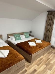 1 dormitorio con 2 camas y toallas. en Cabana Stânceni en Drăgoiasa