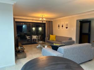 a living room with two couches and a table at Addai Self Catering Brackenfell Durbanville area in Cape Town