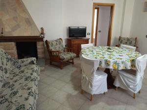 une salle à manger avec une table, des chaises et une cheminée dans l'établissement Casa Is Calitas, à Solèminis