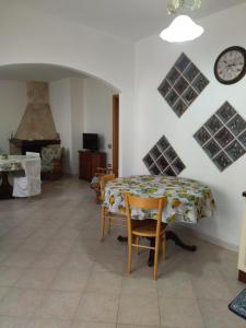 une salle à manger avec une table et une horloge murale dans l'établissement Casa Is Calitas, à Solèminis