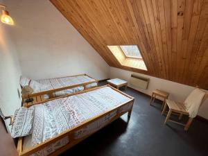 a attic bedroom with two beds and a skylight at Six Duplex à la montagne POMPIERY in Seyne