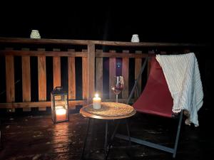 a table with a candle and a glass of wine at Six Duplex à la montagne POMPIERY in Seyne