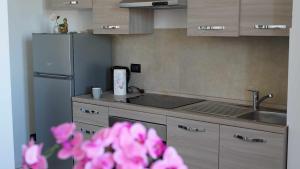 a kitchen with a refrigerator and a sink and pink flowers at Destiny Home 7 Verona Fiera in Verona
