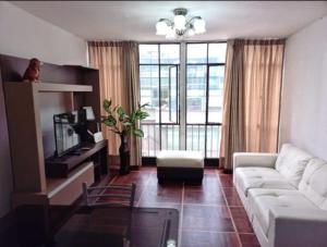 een woonkamer met een witte bank en een groot raam bij Smart Apart Miraflores in Lima