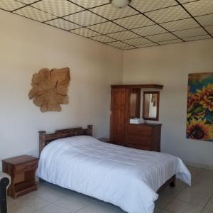1 dormitorio con cama blanca, tocador y espejo en cabanas las molas, en Volcán