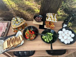 einen Tisch mit Schalen mit Lebensmitteln und Gemüse in der Unterkunft Hotel Blisku do gradot in Skopje