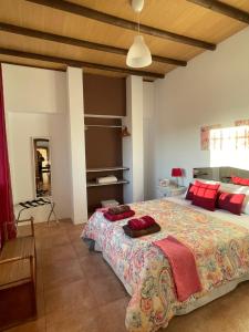 um quarto com uma cama grande e almofadas vermelhas em Casa Rural El Miajon em El Campo