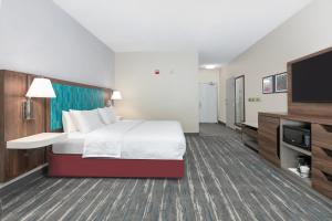 a hotel room with a bed and a flat screen tv at Hampton Inn Kingsville in Kingsville