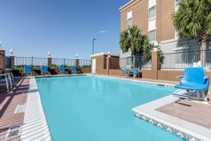 - une piscine avec des chaises bleues dans un bâtiment dans l'établissement Hampton Inn Kingsville, à Kingsville