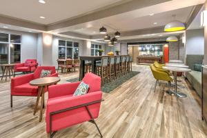 a lobby with red chairs and tables and a bar at Hampton Inn Kingsville in Kingsville
