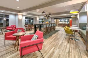 un vestíbulo con sillas y mesas rojas y un bar en Hampton Inn Kingsville, en Kingsville