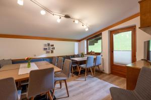 uma sala de jantar com mesas e cadeiras de madeira em Apartments Steindlhof em Schwendau