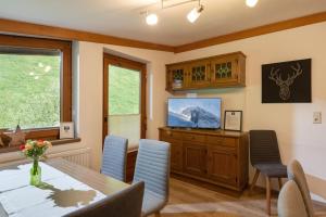 a dining room with a table and chairs and a television at Apartments Steindlhof in Schwendau