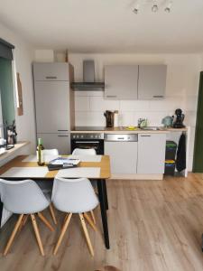 a kitchen with a wooden table and white cabinets at Haus Seewald in Passriach