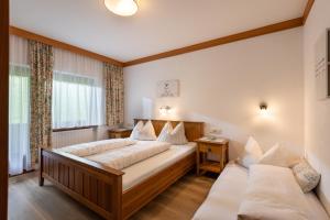 a bedroom with two beds and a couch at Ferienhaus Am Steindl "Steindlhof" in Schwendau +28 photos