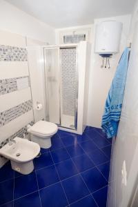 a blue tiled bathroom with two toilets and a shower at Fortuna House - De Vivo Realty Sant'Agnello in Sant'Agnello +10 photos
