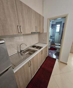 a kitchen with wooden cabinets and a sink in it at Vacanze Pushime Albania in Radhimë