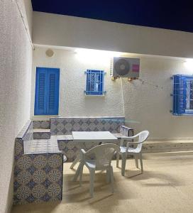 a table and two chairs in front of a building at Charme Bleue-Appartement Magique in Monastir