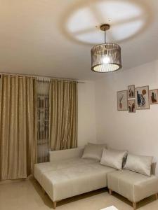 a living room with a couch and a ceiling fan at Charme Bleue-Appartement Magique in Monastir