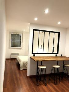Habitación con mesa, taburetes y dormitorio en Gare - Elégant appartement pour pros ou touristes en Chambéry