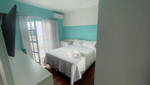 a bedroom with a white bed and a window at Mansão Casa Blanca em São Roque c/ 5 vagas garagem in São Roque