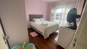 um pequeno quarto com uma cama e uma janela em Mansão Casa Blanca em São Roque c/ 5 vagas garagem em São Roque