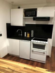 a kitchen with white cabinets and a stove at Gare - Elégant appartement pour pros ou touristes in Chambéry