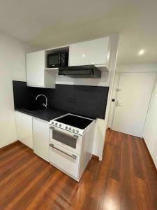 a kitchen with white cabinets and a stove top oven at Gare - Elégant appartement pour pros ou touristes in Chambéry