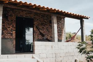 een bakstenen gebouw met een deur in het midden bij Bangalô Alto da Pedreira in Socorro