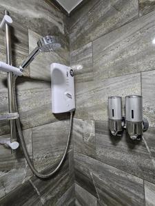 eine Dusche im Bad mit Duschkopf in der Unterkunft Nariken Apartments, Cardiff City Center in Cardiff