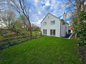 a white house with a fence and a yard at 4BR Country Home Near Cider Barn & Brewery in Axbridge