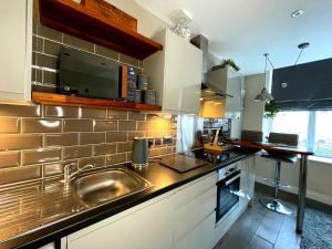 巴恩斯利Town Hall View的厨房里有水槽和微波炉