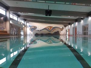 a swimming pool with a painting on the wall at Hotel Stadt Daun in Daun