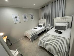 a hotel room with two beds in a room at Addai Self Catering Brackenfell Durbanville area in Cape Town