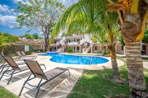 a villa with a palm tree and a swimming pool at Flor de Limon 2 in Coco