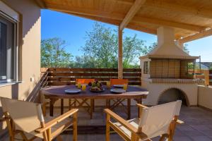 a patio with a table and chairs and a fireplace at Vicky's Lovely Family Home in Argostoli