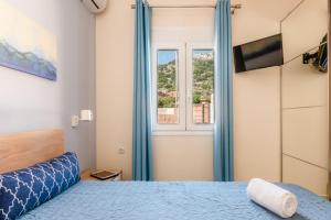 a bedroom with a blue bed and a window at Vicky's Lovely Family Home in Argostoli