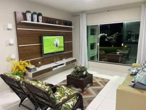 a living room with a flat screen tv on a wall at Casalagorios - ilha de Itaparica - Berlinque in Vera Cruz de Itaparica