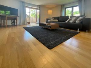 een woonkamer met een bank en een tapijt bij Holiday apartment lucky guy in Oberstaufen