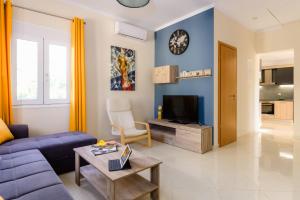 a living room with a couch and a tv at Vicky's Lovely Family Home in Argostoli