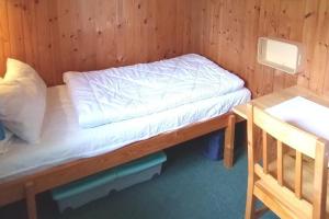 Kleines Zimmer mit einem Bett und einem Schreibtisch. in der Unterkunft Holiday home Hunning in Hünning