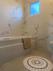 een witte badkamer met een bad en een wastafel bij Hannahs Cottage 