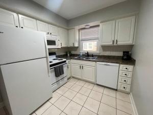 - une cuisine avec des appareils électroménagers et des armoires blanches dans l'établissement Cathedral View 10-Cozy Urban Living Near UNMC, à Omaha