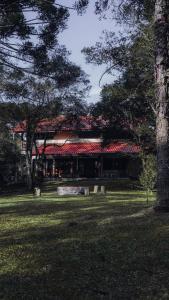 un edificio con tetto rosso in un parco di CURTA! | Casa dos Pássaros - CA (Piso Superior) a Campo Alegre