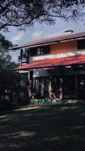 una grande casa con tetto rosso di CURTA! | Casa dos Pássaros - CA (Piso Superior) a Campo Alegre