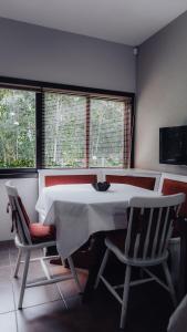 una sala da pranzo con un tavolo bianco e due sedie di CURTA! | Casa dos Pássaros - CA (Piso Superior) a Campo Alegre