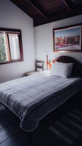 un grande letto in una camera da letto con due finestre di CURTA! | Casa dos Pássaros - CA (Piso Superior) a Campo Alegre